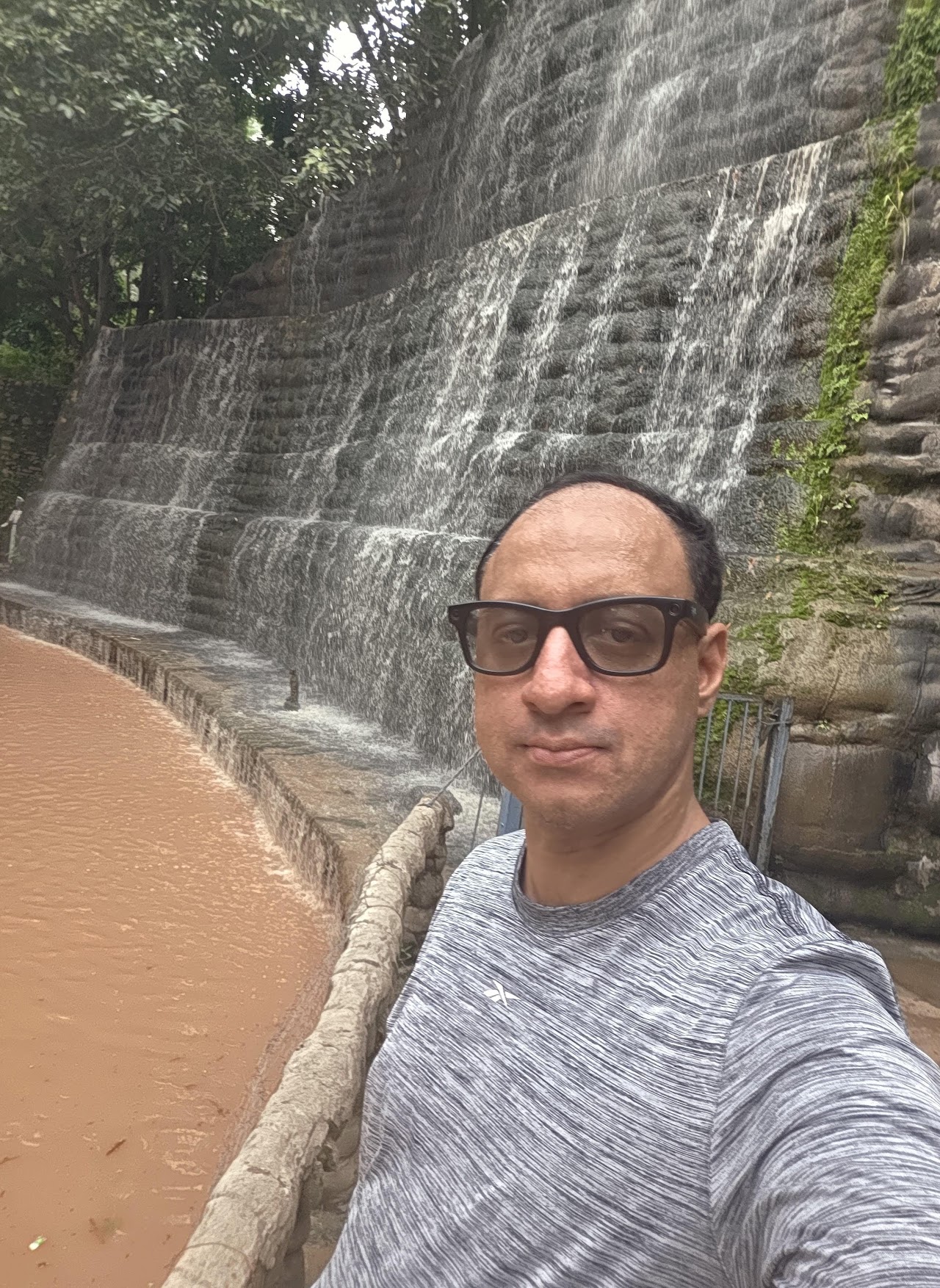 Shivam beside a waterfall